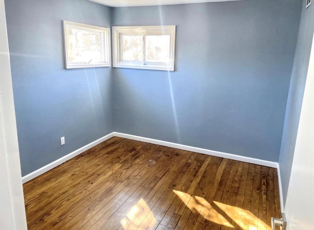 empty room featuring hardwood / wood-style floors and baseboards