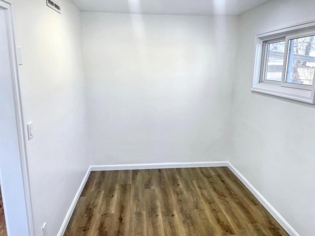 unfurnished room featuring baseboards and wood finished floors