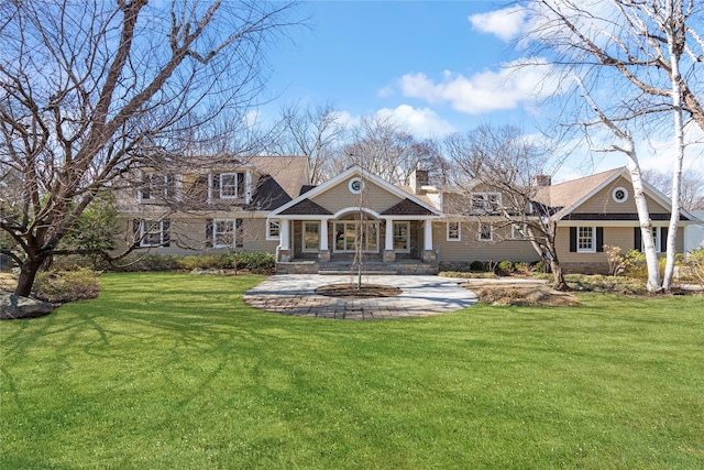 exterior space with a porch, a chimney, and a yard