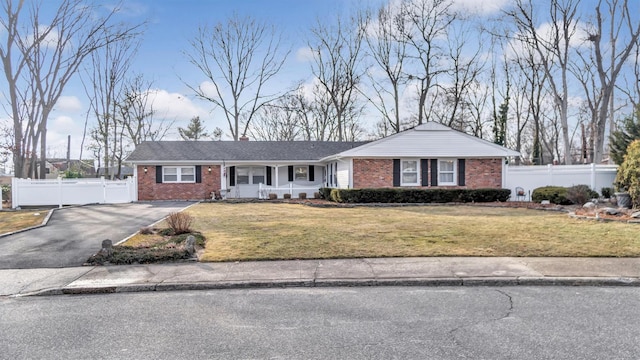 single story home featuring aphalt driveway, a front yard, fence, and brick siding