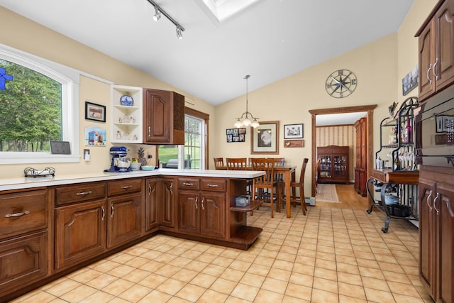 kitchen with light countertops, an inviting chandelier, open shelves, and lofted ceiling