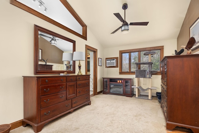 sitting room with baseboards, ceiling fan, light colored carpet, an AC wall unit, and vaulted ceiling