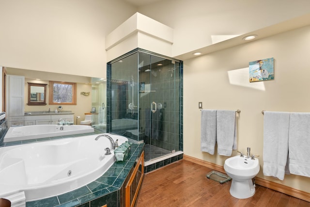 bathroom featuring baseboards, a tub with jets, wood finished floors, a bidet, and a stall shower