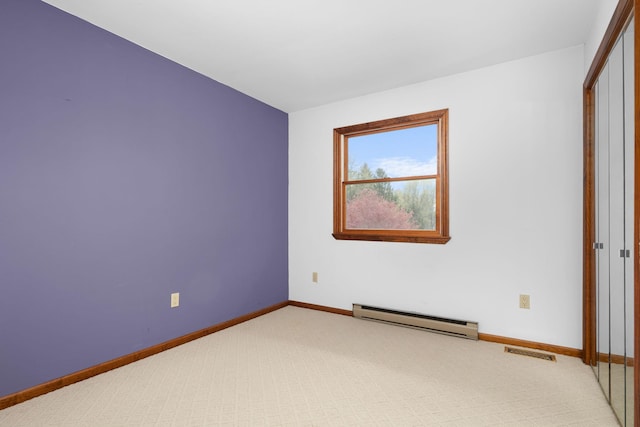carpeted empty room with baseboards, baseboard heating, and visible vents
