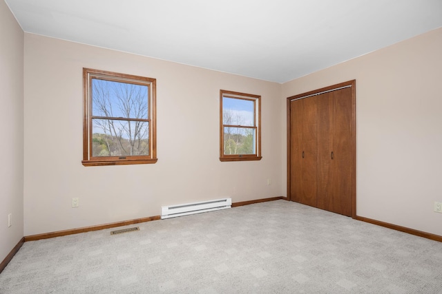 unfurnished bedroom with visible vents, baseboards, baseboard heating, and a closet
