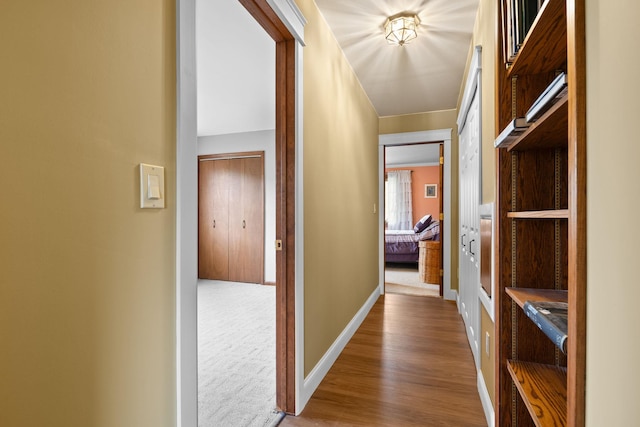 hallway featuring baseboards and wood finished floors