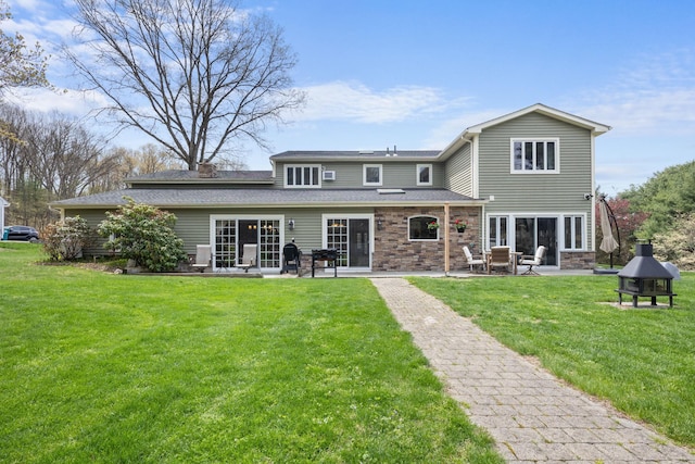 back of property featuring a patio, roof with shingles, a yard, and a chimney