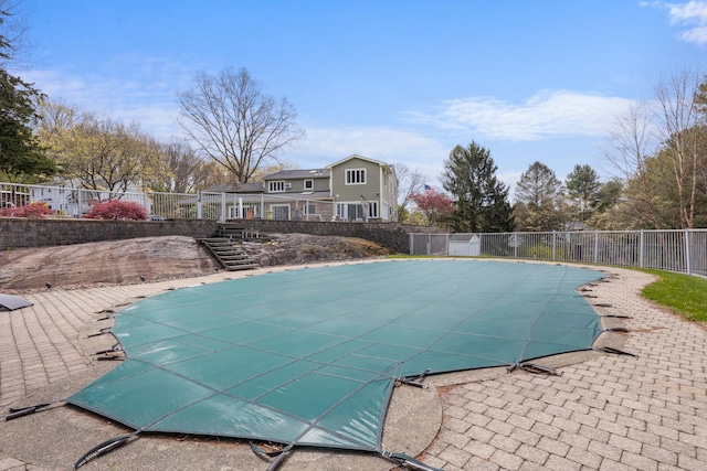 view of swimming pool featuring a fenced in pool, a patio area, fence, and stairway