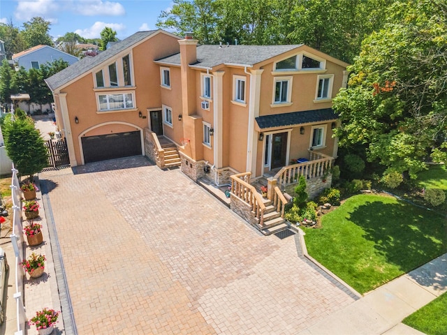 view of front of house with a chimney, an attached garage, fence, decorative driveway, and stucco siding