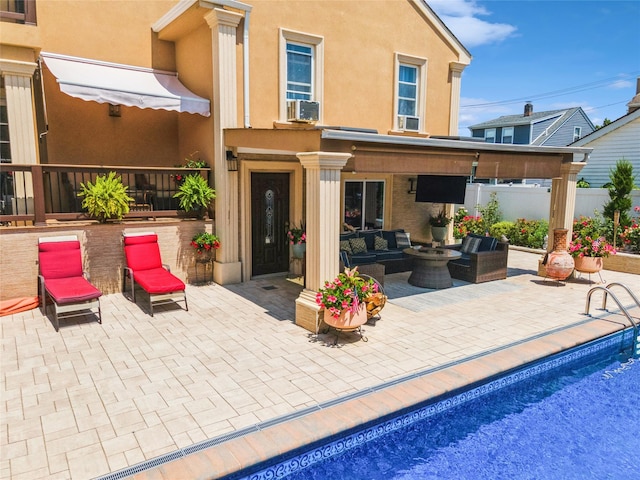 back of property with an outdoor hangout area, a patio area, fence, and stucco siding