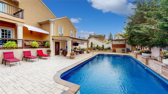 view of pool featuring a patio, a fireplace, fence, and a fenced in pool