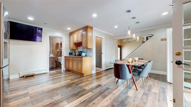 kitchen featuring baseboards, baseboard heating, wood finished floors, and crown molding