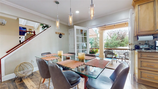 dining room featuring ornamental molding, baseboards, and wood finished floors