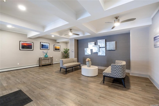 sitting room featuring ceiling fan, beam ceiling, baseboards, and wood finished floors