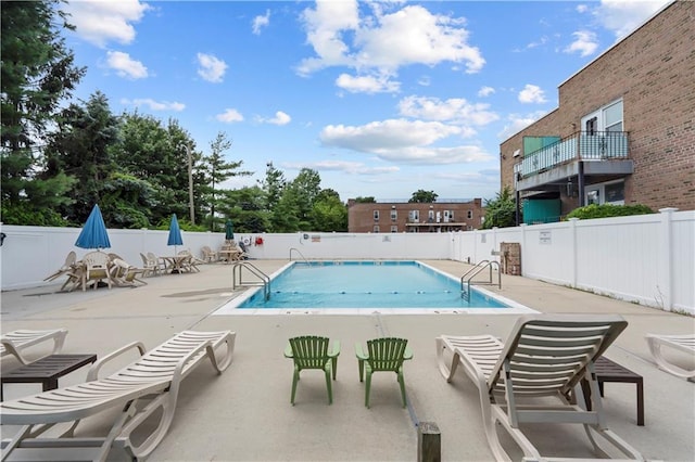 pool with a patio area and fence