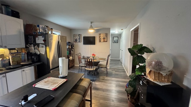 dining area with dark wood-style floors, ceiling fan, and baseboards