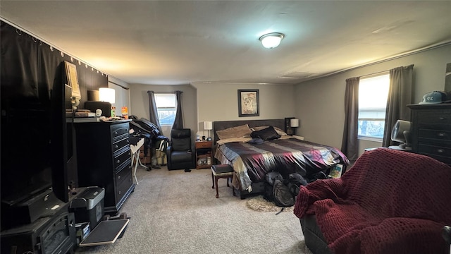 bedroom with light carpet and multiple windows