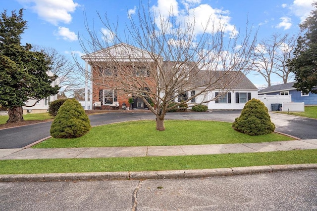 view of front facade with aphalt driveway and a front yard