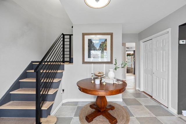 entrance foyer featuring stairway and baseboards