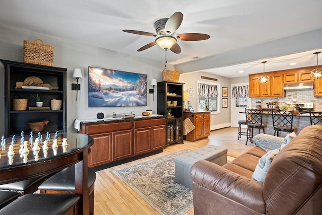 living room featuring light wood-style floors and a ceiling fan