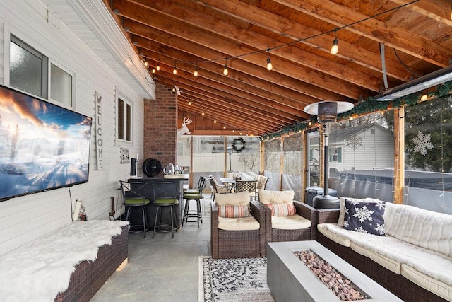 view of patio with outdoor dining area and an outdoor living space with a fire pit