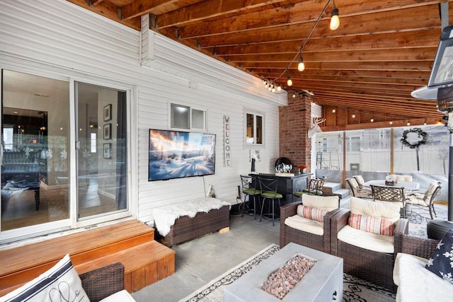 view of patio with an outdoor living space with a fire pit