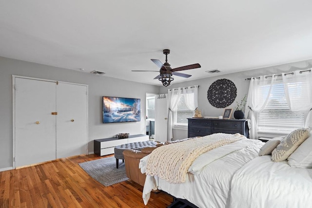 bedroom with visible vents, a ceiling fan, and wood finished floors