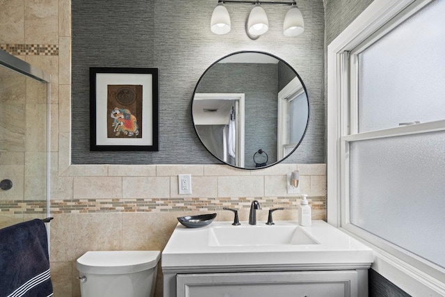 bathroom with tile walls, a tile shower, vanity, and toilet