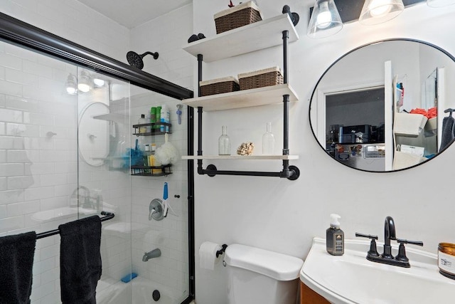 bathroom featuring toilet, bath / shower combo with glass door, and vanity