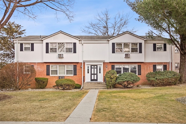 view of front of property with brick siding, crawl space, and a front yard