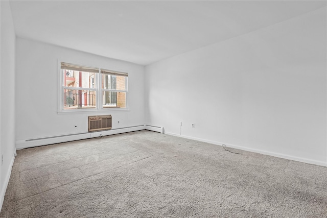 spare room with a baseboard heating unit, carpet flooring, and baseboards