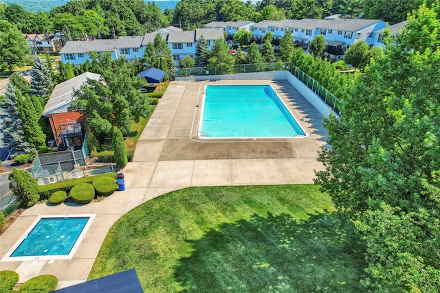 view of swimming pool featuring a fenced in pool, a residential view, a yard, and fence