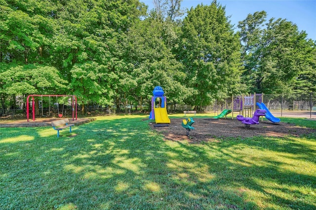 community play area featuring fence and a lawn