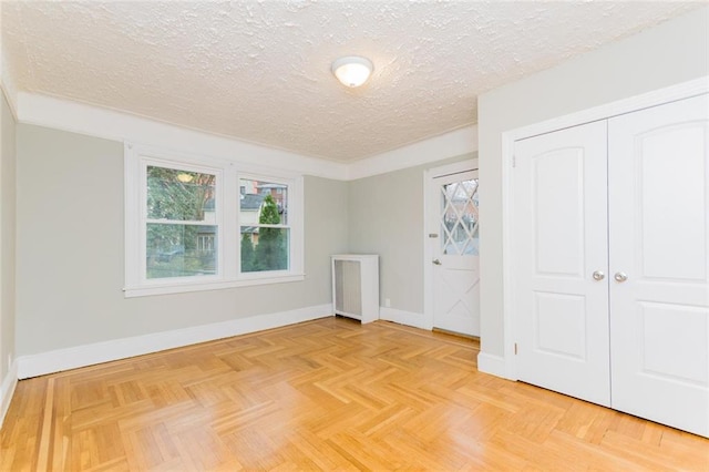 unfurnished bedroom with a closet, baseboards, and a textured ceiling