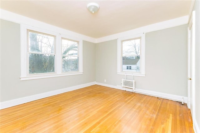 spare room featuring light wood-style flooring and baseboards