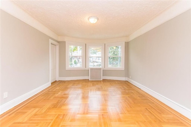 empty room with a textured ceiling and baseboards