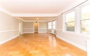 unfurnished room with radiator and baseboards