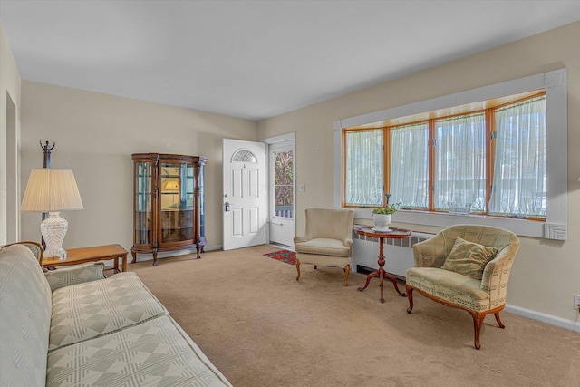 carpeted living area with baseboards and radiator heating unit