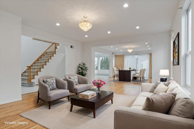 living area with light wood-style floors, recessed lighting, visible vents, and stairs