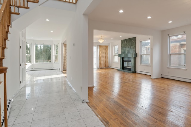 foyer featuring a baseboard radiator, a fireplace, stairway, and recessed lighting