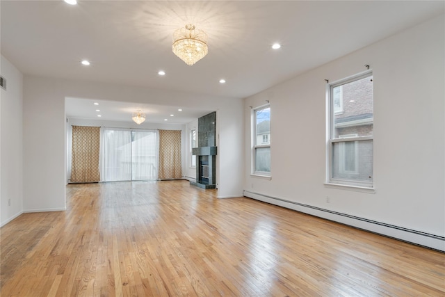 unfurnished living room featuring a baseboard heating unit, recessed lighting, a tiled fireplace, and light wood finished floors