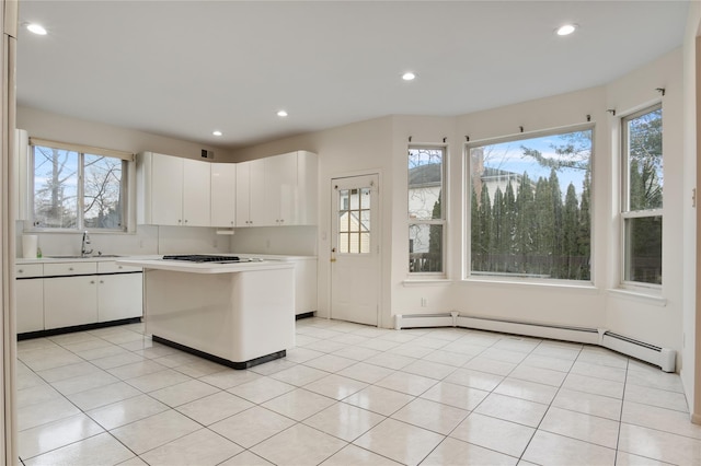 kitchen with white cabinets, light tile patterned floors, light countertops, and a sink