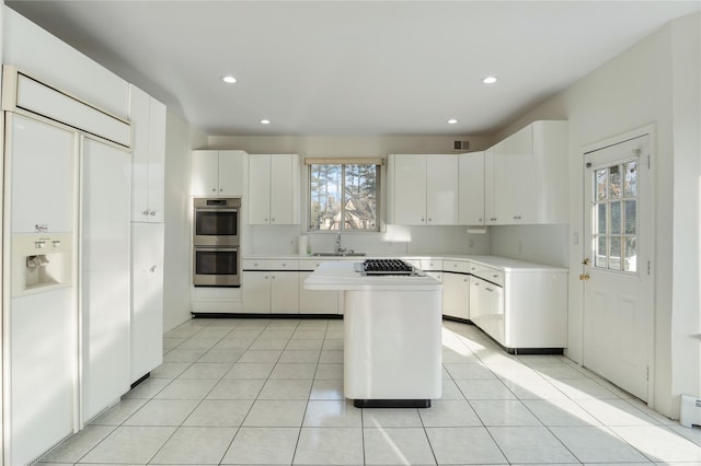 kitchen with light tile patterned floors, stainless steel appliances, a kitchen island, and light countertops