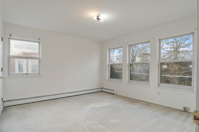 unfurnished room with a baseboard heating unit and light carpet