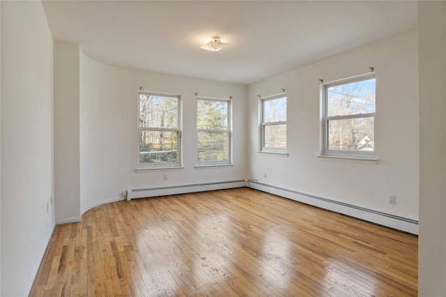 empty room featuring a baseboard heating unit and light wood-style floors