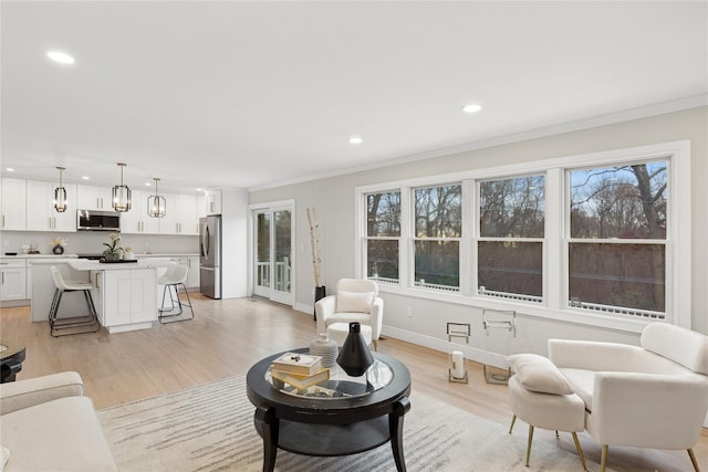 living room featuring recessed lighting, baseboards, light wood-style floors, ornamental molding, and plenty of natural light