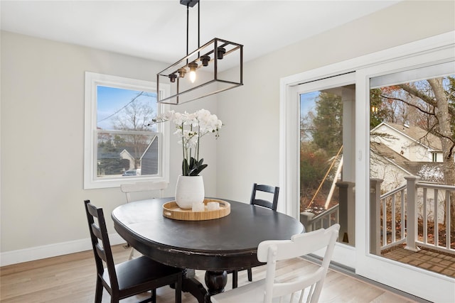 dining space with light wood-style floors and baseboards