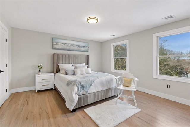 bedroom featuring light wood-style floors, baseboards, and visible vents