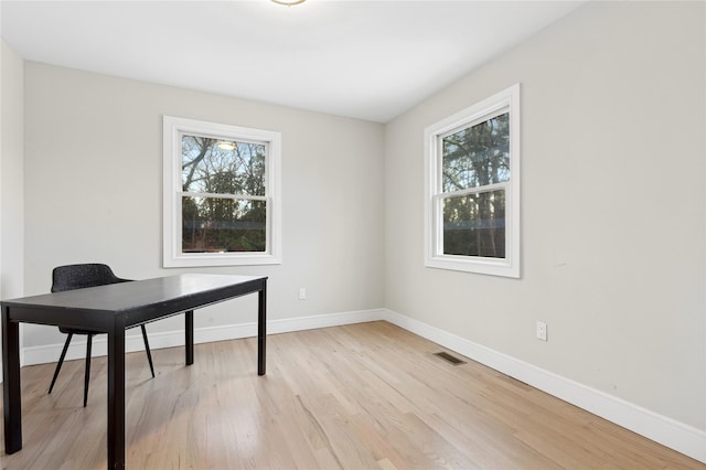 office with light wood finished floors, plenty of natural light, visible vents, and baseboards