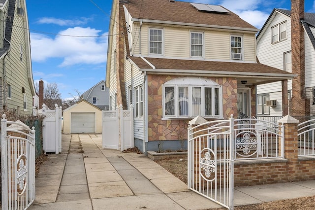 view of front of house featuring an outdoor structure, a detached garage, fence, concrete driveway, and a gate